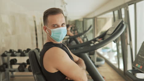 Young-Strong-Athlete-Male-Man-With-Face-Mask-Looking-To-Camera-In-The-Gym