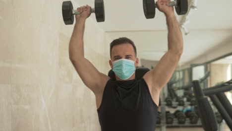 Strong-Male-With-Face-Mask-Lifts-Weights-And-Exercises-In-The-Gym