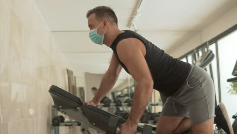 Strong-Male-With-Face-Mask-Lifts-Weights-And-Exercises-In-The-Gym-1