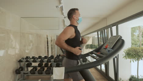 Athlete-Male-With-Face-Mask-Uses-Treadmill-In-The-Gym