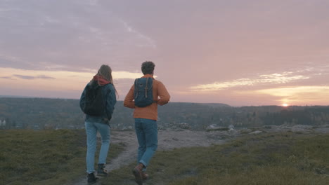 -Beautiful-sunset-Young-couple-of-female-and-male-hikers-at-the-top-of-the-mountain