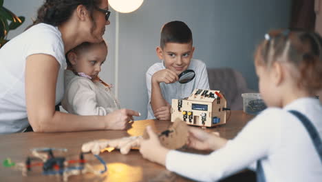 Female-Teacher-Helps-Little-Boy-And-Girls-Interested-In-Science-And-Technology-To-Build-Robots