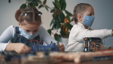 Little-Girls-With-Face-Mask-Building-Robots-1