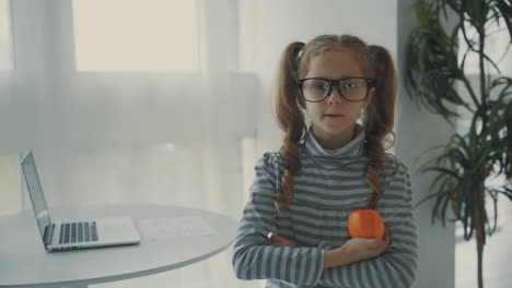Little-Girl-With-Glasses-Holds-A-Fruit