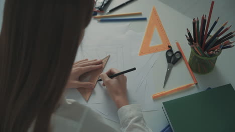 Unrecognizable-Female-Teacher-Drawing-Geometric-Shapes-At-Her-Desk