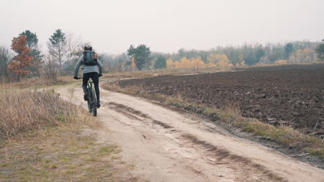 Athlete-Man-Riding-A-Mountain-Bike-Down-A-Road-In-The-Countryside