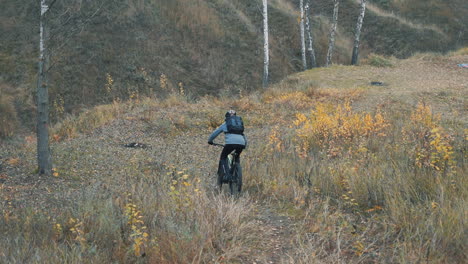 Athlete-Man-With-Backpack-And-Helmet-Riding-A-Mountain-Bike-Down-The-Hill