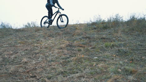 Athlete-Cyclist-Man-With-Backpack-And-Helmet-Riding-A-Mountain-Bike-Down-The-Hill
