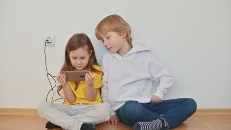 Kleiner-Junge-Und-Mädchen,-Die-Ein-Smartphone-Benutzen-Und-Zu-Hause-Online-Videos-Ansehen