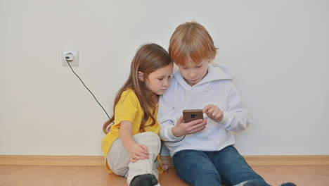 Little-Boy-And-Girl-With-A-Smartphone-Using-An-App