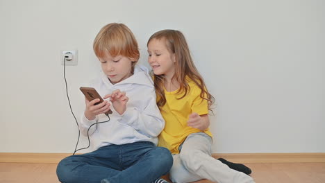Kleiner-Junge-Und-Mädchen-Mit-Einem-Smartphone,-Das-Eine-App-Verwendet-Und-Ein-Online-Videospiel-Spielt
