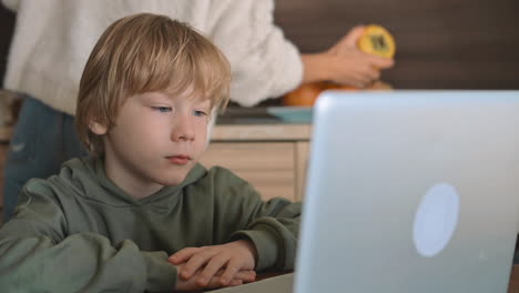 Little-Boy-And-Mother-Watching-Laptop-At-Home