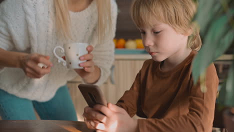 Kleiner-Junge-Und-Mutter-Schauen-Smartphone-Und-Benutzen-Eine-App-Zu-Hause