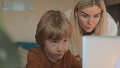 Kleiner-Junge,-Der-Zu-Hause-Online-unterricht-Mit-Laptop-Hat,-Mutter-Hilft