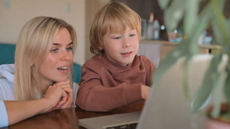 Little-Boy-And-Mother-Watching-Laptop-And-Having-Fun-At-Home