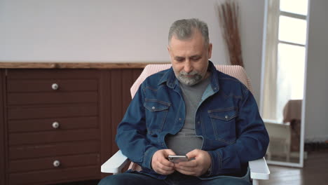 Mature-Man-Using-His-Phone-Chatting-And-Texting