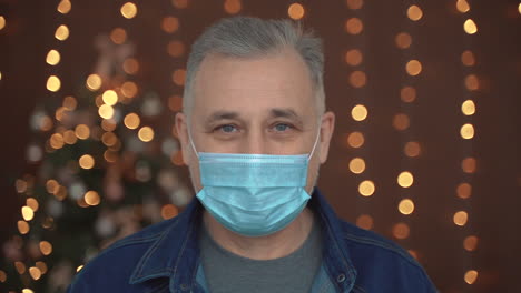 Portrait-Of-Mature-Man-Taking-Off-The-Face-Mask-Looking-At-Camera-Smiling
