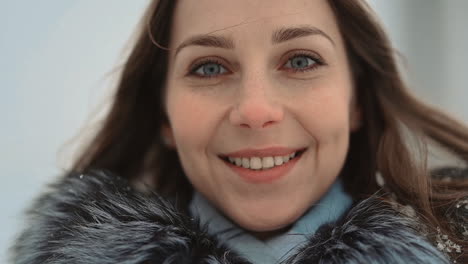 Nahaufnahme-Porträt-Einer-Frau,-Die-In-Winterkleidung-In-Die-Kamera-Blickt-Und-Lächelt