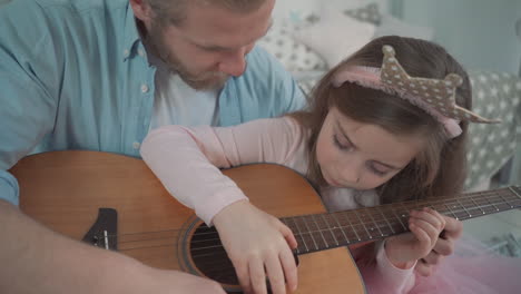 Kleine-Tochter,-Die-Als-Prinzessin-Verkleidet-Ist,-Spielt-Mit-Ihrem-Papa-Zu-Hause-Gitarre