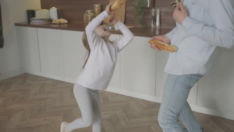 Dad-And-Daughter-Sing,-Dance-And-Play-With-Food-At-Home