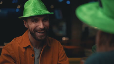 Porträt-Eines-Glücklichen-Mannes-Mit-Irischem-Hut,-Der-Mit-Freunden-In-Einem-Pub-Spricht