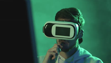 Portrait-Of-A-Man-Using-A-Vr-Headset-And-Vaping-On-A-Colorful-Neon-Light-Background