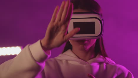 Female-Using-A-Vr-Headset-On-A-Colorful-Neon-Light-Background