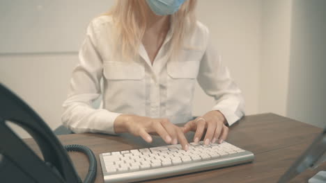 Close-Up-Of-Business-Female-With-Face-Mask-Using-A-Computer-In-The-Office