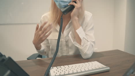 Close-Up-Of-Youn-Woman-With-Face-Mask-Having-A-Business-Call-In-The-Office
