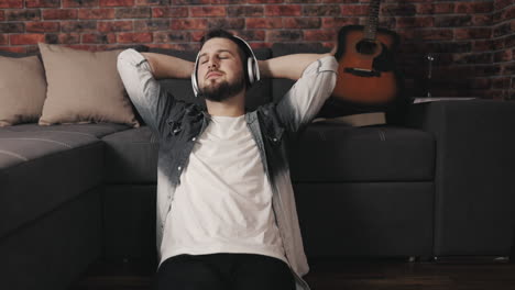 Young-Musician-Man-Listening-To-Music-With-Wireless-Headphones-And-Singing-At-Home