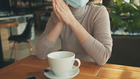 Portrait-Of-Young-Woman-With-Face-Mask-Talking-To-Her-Friend-In-A-Coffee-Shop