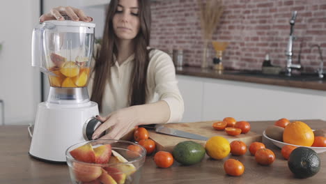 Young-Pretty-Woman-Preparing-Fruit-Juice-With-Blender