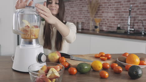 Young-Female-Preparing-Fruit-Juice-With-Blender