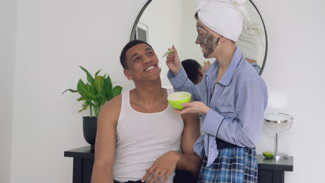 Woman-Applying-Facial-Mask-To-A-Handsome-Black-Man