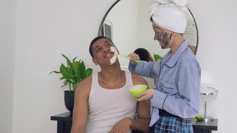 Female-Applying-Facial-Mask-To-A-Handsome-Black-Man