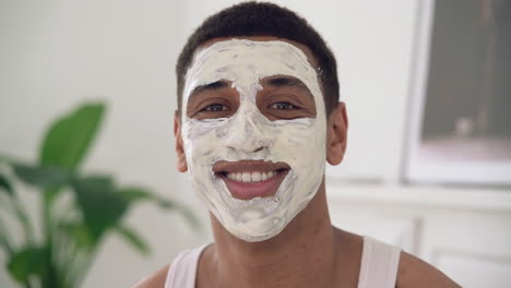 Portrait-Of-A-Handsome-Black-Man-With-Facial-Mask-Looking-At-Camera-And-Smiling