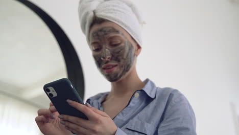 Woman-With-Facial-Mask-Using-A-Smartphone