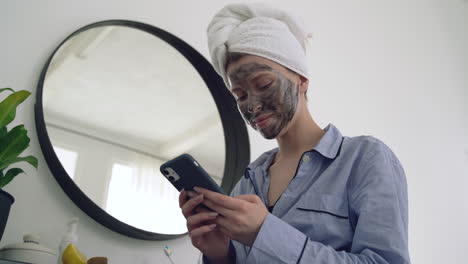 Frau-Mit-Gesichtsmaske-Mit-Einem-Smartphone