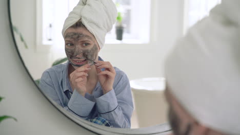Frau-Entfernt-Die-Gesichtsmaske-Und-Schaut-In-Den-Spiegel