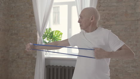 Old-Man-Using-A-Stretching-Band-And-Exercising-At-Home
