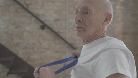 Old-Man-Using-A-Stretching-Band-And-Exercising-At-Home-2