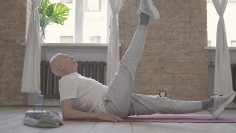 Old-Man-Stretching-And-Exercising-On-Yoga-Mat-At-Home-1