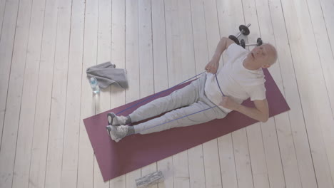 Old-Man-Using-A-Stretching-Band-And-Exercising-On-Yoga-Mat-At-Home-1