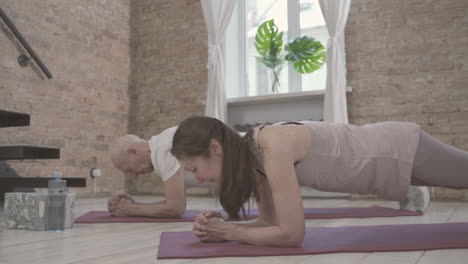Old-Female-And-Male-On-Yoga-Mat-At-Home