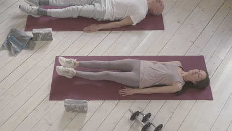 Old-Male-And-Female-Exercising-On-Yoga-Mat-At-Home