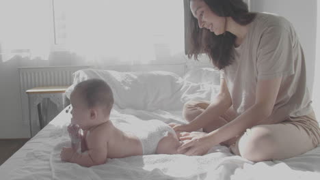 Happy-Mom-Taking-Care-Of-Her-Cute-Baby-In-The-Bedroom