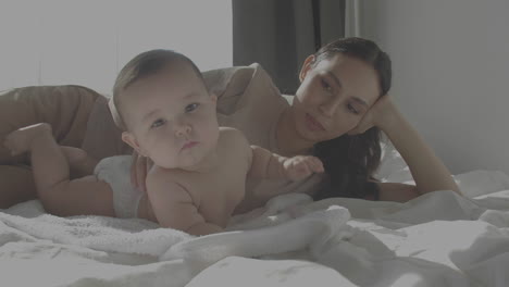 Cute-Happy-Baby-And-Mom-Laying-In-Bed