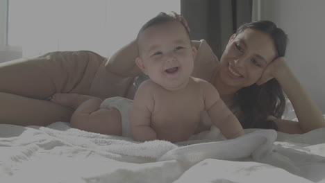Cute-Smiley-Happy-Baby-And-Mom-Laying-In-Bed