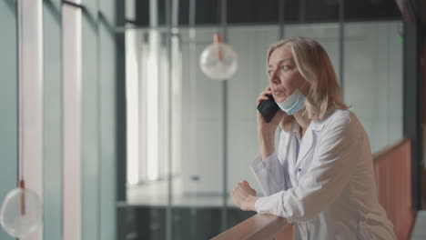 A-Blonde,-Middle-Aged-Female-Doctor-Talks-On-The-Cell-Phone