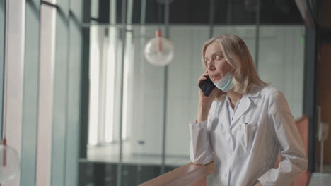 A-Blonde,-Middle-Aged-Female-Doctor-Talks-On-The-Cell-Phone-1